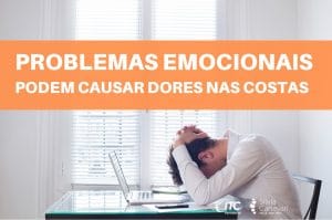 Homem sentado com as mãos na cabeça inclinada para baixo.